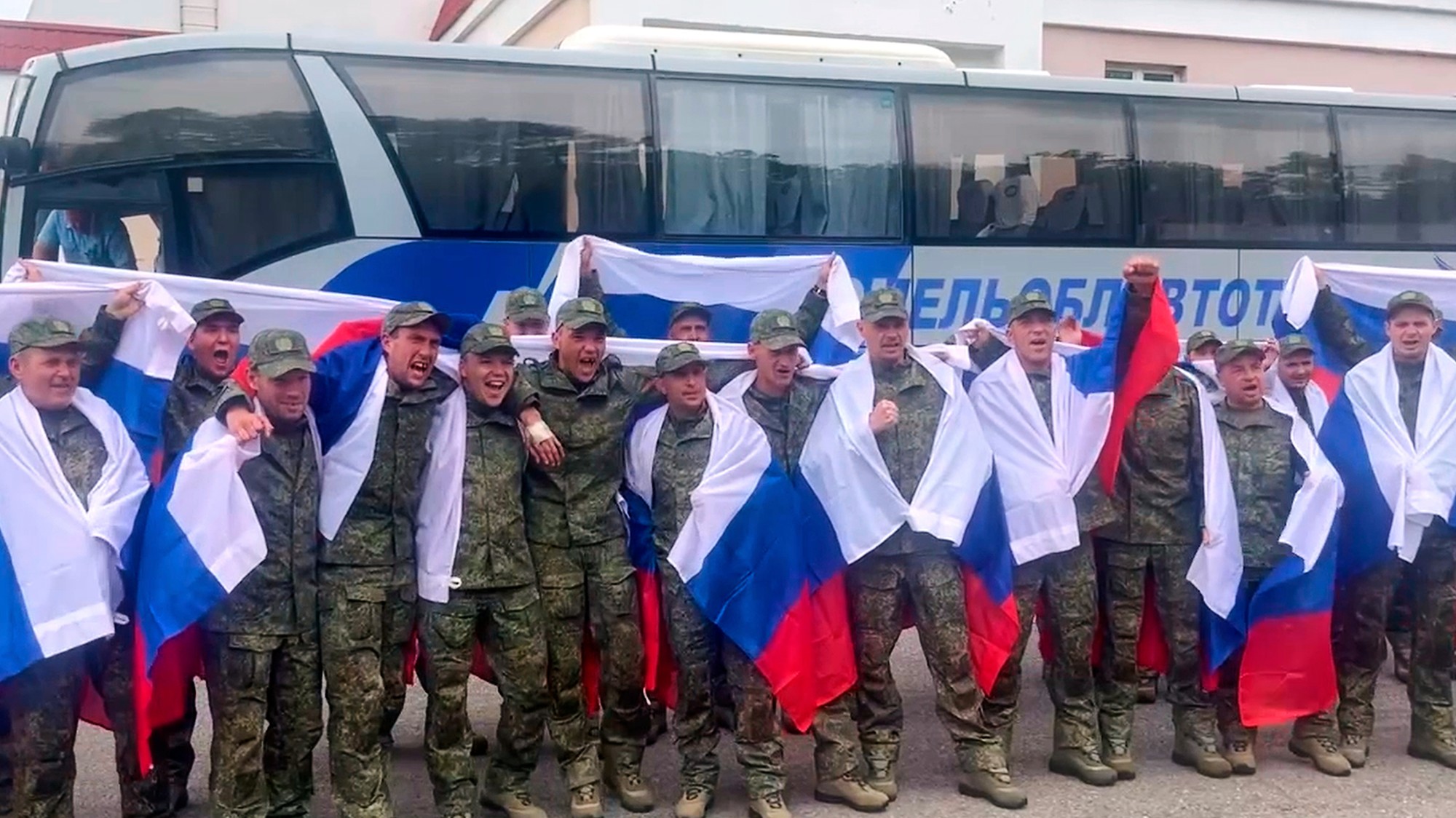 Ruské ministerstvo obrany a zverejnilo fotografie vojakov zahalených do ruských vlajok, ako pri príchode jasajú a mávajú.