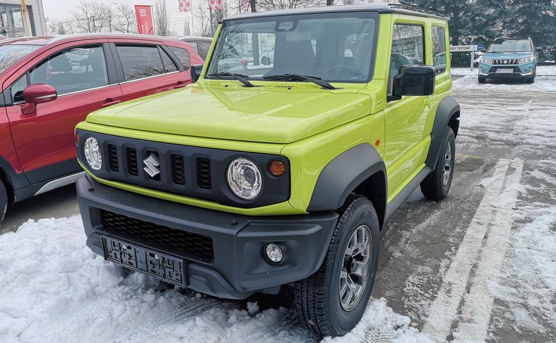 Suzuki Jimny swoją pudełkowatą trzydrzwiową karoserią w energetycznym kolorze kinetic yellow z łatwością wywołuje uśmiech wielkości banana