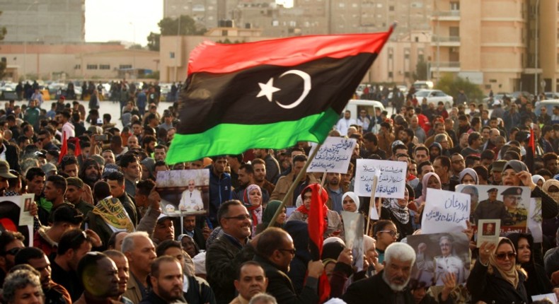 Supporters of Libyan military strongman Khalifa Haftar wave a national flag in a February 2020 demonstration in Benghazi