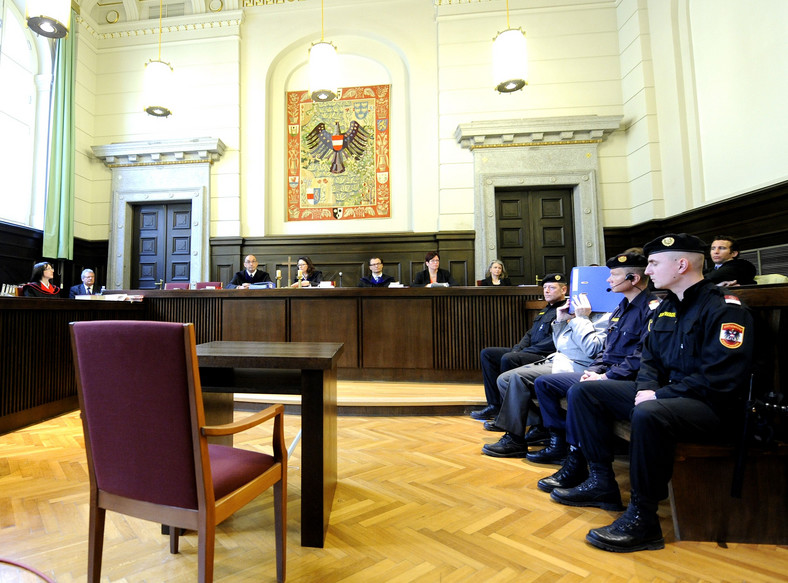 Proces Josefa Fritzla, marzec 2009 r. Fritzl siedzi na ławce po prawej, zasłania swoją twarz teczką 