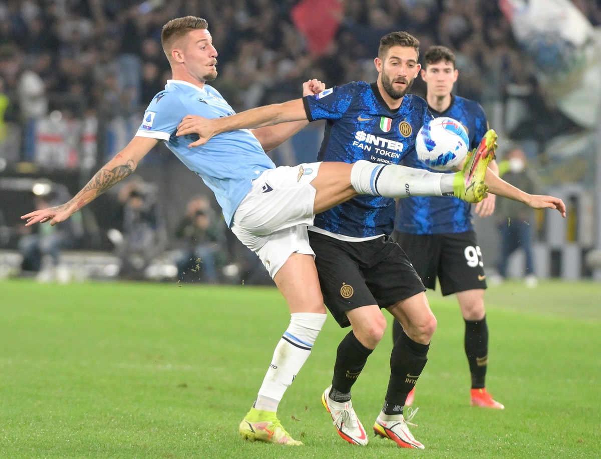 Piłkarz Lazio Rzym Sergej Milinković-Savić (L) w starciu z zawodnikiem Interu Roberto Gagliardinim (C) podczas meczu ligi włoskiej