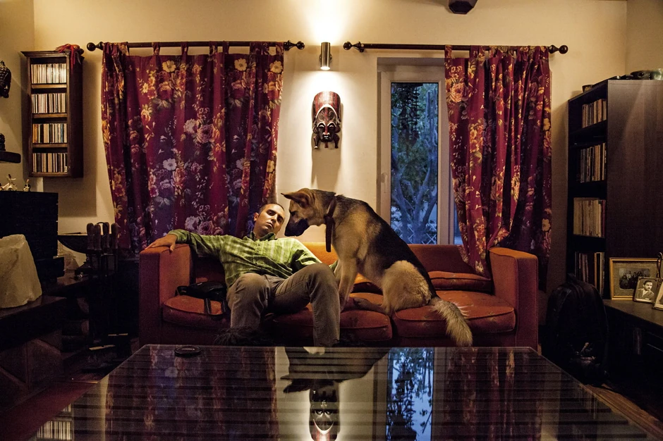 Mohamed sedi na kauču sa svojom ljubimicom Lusi. Kretanje sa psima u javnosti nije dozvoljeno, pa vlasnici moraju da provode više vremena kod kuće (FOTO: Fabrica)