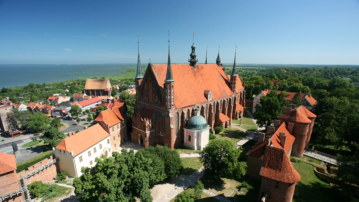 Góruje nad krajobrazem. Potężna, opięta murem, strzeżona przez wieże i basteje katedra-forteca. A u jej stóp? Malutki Frombork. Pachnące historią miasteczko z wtulonym w wody Zalewu Wiślanego portem. Popołudniami gwarne, wieczorem ścisza głos i uwodzi senną atmosferą warmińskiej prowincji.