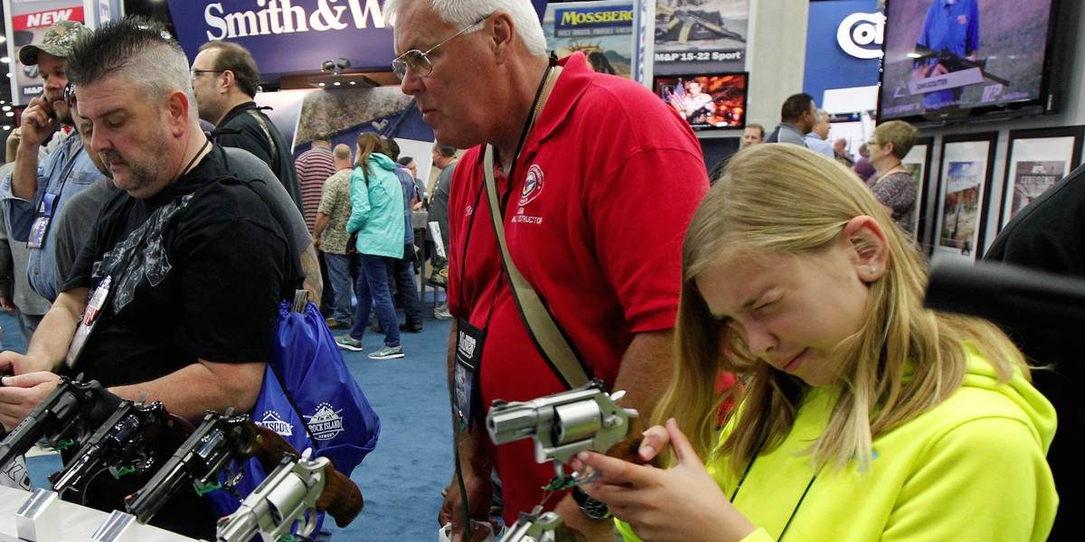 Kelsey Bartley (10) looks over Smith & Wesson guns with her dad Rick Bartley at the National Rifle Association's (NRA) annual meetings & exhibits show in Louisville, Kentucky, May 21, 2016.