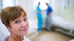 Portrait of smiling patient sitting on bed