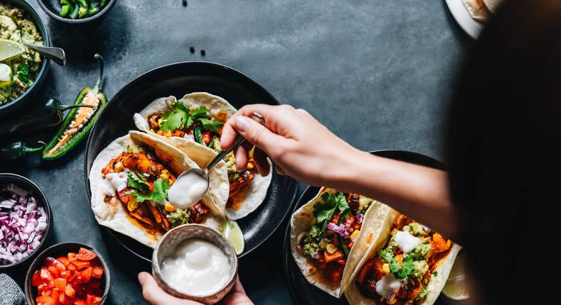 Aim to get 30 grams of protein and 10 grams of fiber per meal for simpler healthy eating. A good example is tacos with black beans, avocado, and meat topped with sour cream and cheese. alvarez/Getty Images