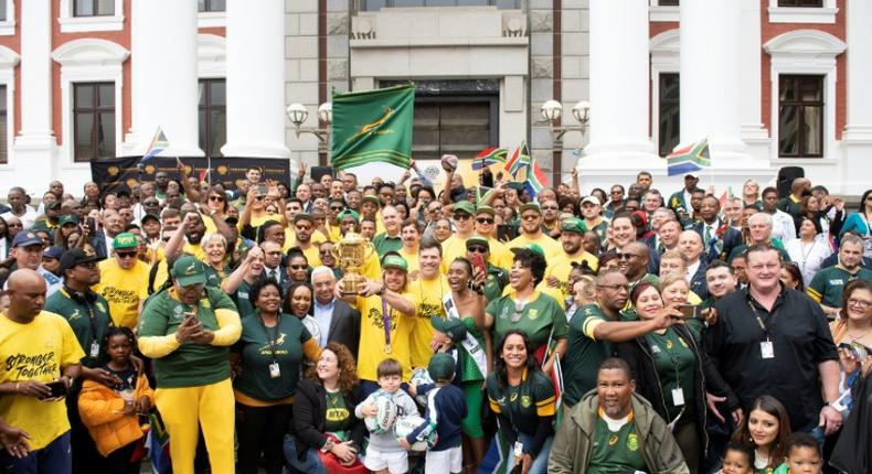 Rainbow nation: Springbok scrum half Faf de Klerk holds the William Webb Ellis Trophy alongside his teammates outside the South African parliament in Cape Town