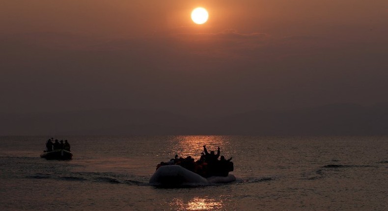 Refugees and migrants wave as they approach the shores of the Greek island of Lesbos on a dinghy during sunrise, March 20, 2016. REUTERS/Alkis Konstantinidis