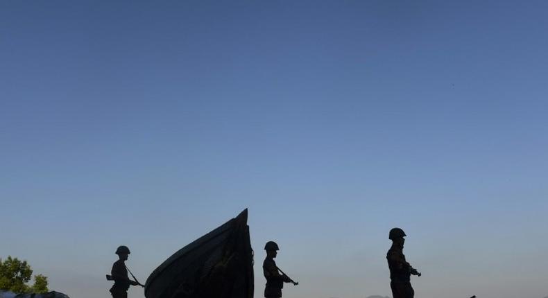 Bangladesh soldiers stand guard as they try to stop the illegal entry of Myanmar Rohingya refugees on the banks of the Naf River