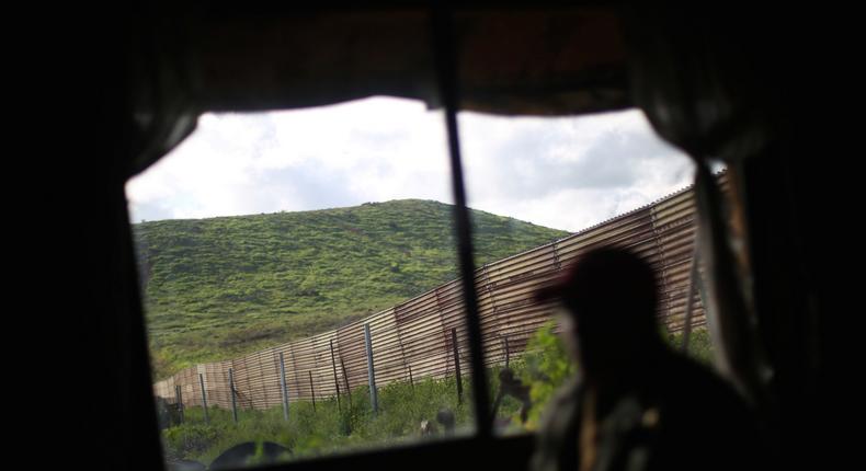 Pensioner Pedro, 72, is seen at his house near a section of the fence separating Mexico and the United States, on the outskirts of Tijuana, Mexico.