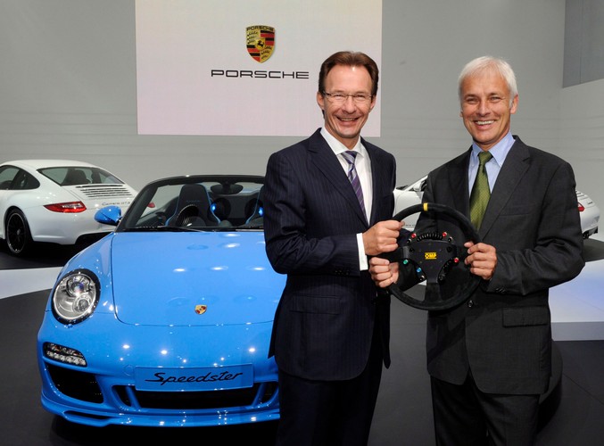 Szef Porsche Michael Macht (po lewej) przekazuje symboliczną kierownicę swojemu następcy Matthiasowi Muellerowi