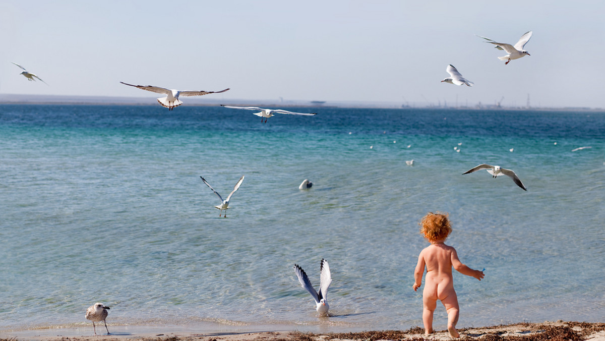 Jeszcze dwadzieścia lat temu biegające po plaży nago dzieci na nikim nie robiły wrażenia. Maluchy biegały po brzegu z wypiekami na twarzy, na wyścigi wpadając z hukiem do wody, budując zamki z piasku i błagając rodziców o jeszcze jedną porcję lodów. Czysta beztroska. Dziś zwolenników takiej swobody dzieci na plaży jest coraz mniej, ale ci, którzy się na nią decydują, muszą zmierzyć się zarówno z takimi zagrożeniami jak pedofilia, jak i społecznym oburzeniem i odrzuceniem.