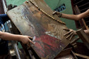 Children recover a picture depicting Jesus Christ from the mud after the flooding of their homes in the low-income neighborhood of Antimano in Caracas