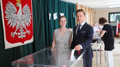 Krzysztof Bosak (C) z żoną Kariną (L) podczas głosowania w lokalu wyborczym w XXX LO im. Jana Śniadeckiego w Warszawie.