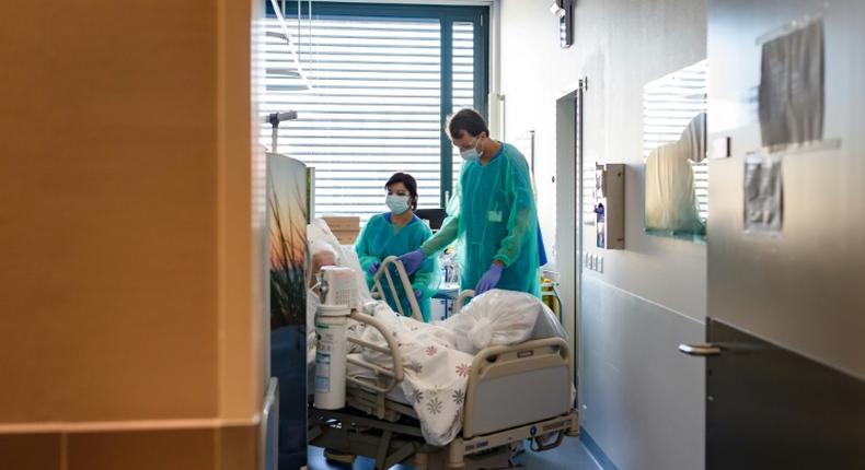 A Swiss soldier (R) helps to move the bed of a COVID-19 patient, at the Pourtales Hospital in Neuchatel on March 25, 2020, after Switzerland deployed its army reservists to relieve hospitals under pressure from the outbreak of COVID-19