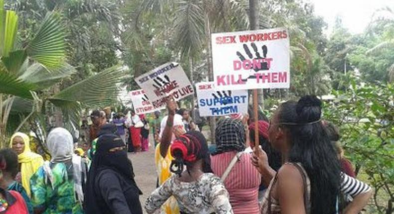 Kenyans prostitutes hold placards in protest over the murder of their colleague.