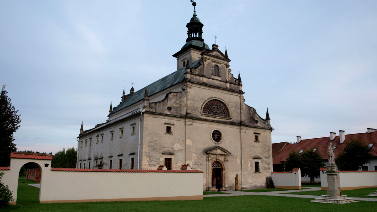 Cisza. Gęsta, oblepiająca cisza. Uszy atakuje jedynie cykanie świerszczy. Nawet psiak wałęsający się w pobliżu dostosowuje się do spokoju i tylko bezdźwięcznie łasi do nóg. Stoimy w środku lasu. Najbliższe zabudowania oddalone są o ponad 2 kilometry.