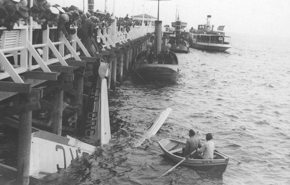 Tłum gapiów obserwuje wydobywanie z wody wraku samolotu w 1936 r. 