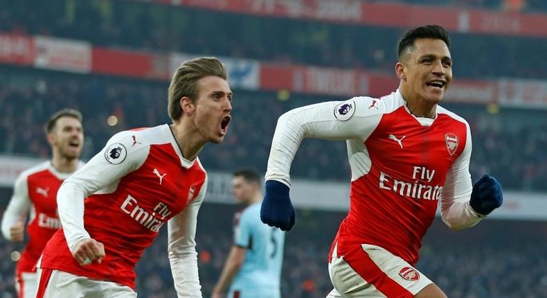Arsenal striker Alexis Sanchez (R) celebrates with teammate Nacho Monreal after scoring a late winner from the penalty spot during the English Premier League match against Burnley at the Emirates Stadium in London on January 22, 2017
