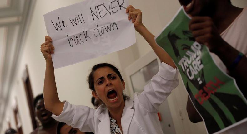 Activists protest the GOP healthcare bill in the halls of the Senate on July 19, 2017.