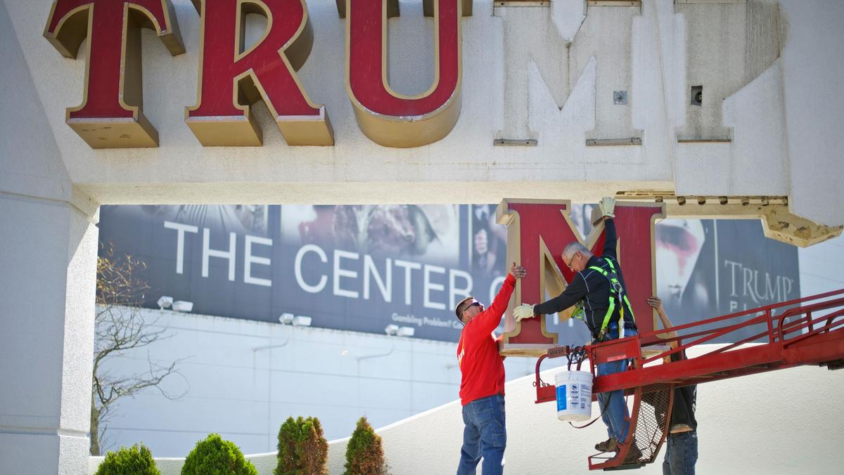 Williams, of Calvi Electric, lowers the 'M' letter from the signage of Trump Plaza Casino to his co-