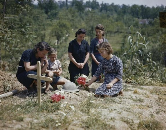 Rodzina brytyjskiego żołnierza poległego w walkach o Monte Cassino składa kwiaty na jego grobie (domena publiczna).