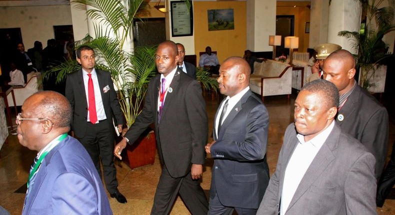 Burundi President Pierre Nkurunziza, (surrounded by security officers), is led by Tanzania Director General of Intelligence and Security Services, (DG-TISS), Rashid Othman (L), on his way to the Julius Nyerere International Airport in Dar es Salaam, Tanzania, May 13, 2015.  REUTERS/Stringer