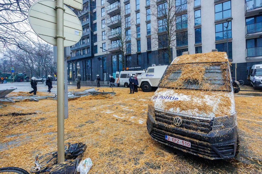 Samochód policyjny pokryty sianem podczas protestu europejskich rolników w Brukseli. 26 lutego 2024 r.