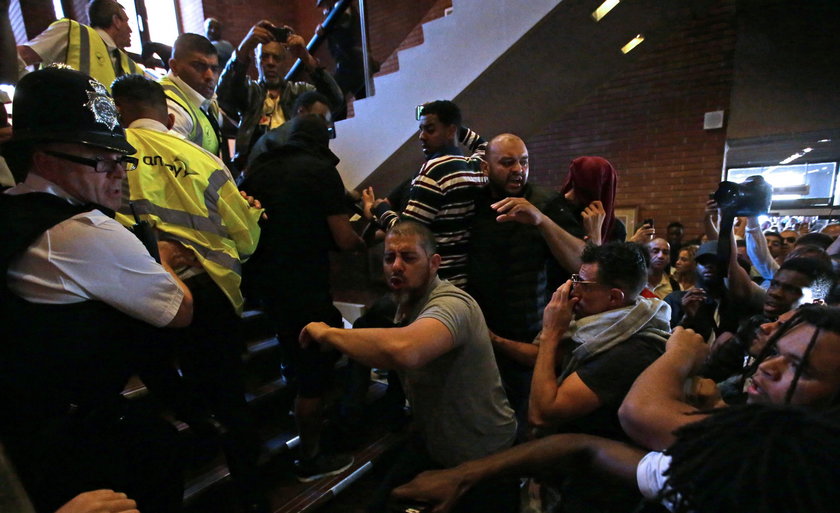 Demonstrators confront a man they believe to be Robert Black, the Chief Executive of KCTMO, outside 