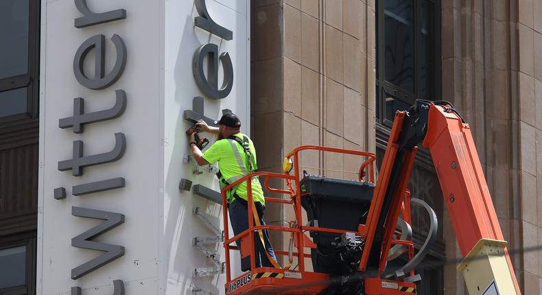 A worker removed the Twitter sign from the company's headquarters after owner Elon Musk renamed it X.Justin Sullivan/Getty Images