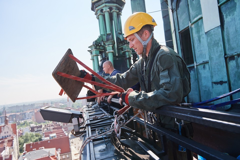 Alpinista dokonuje oględzin mechanizmów zegara Ratusza Głównego Miasta w Gdańsku