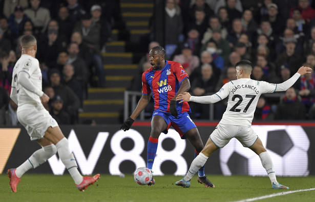 Piłkarz Crystal Palace Jean-Philippe Mateta (C) i w starciu z zawodnikiem Manchesteru City Joao Cancelo (P) podczas meczu ligi angielskiej