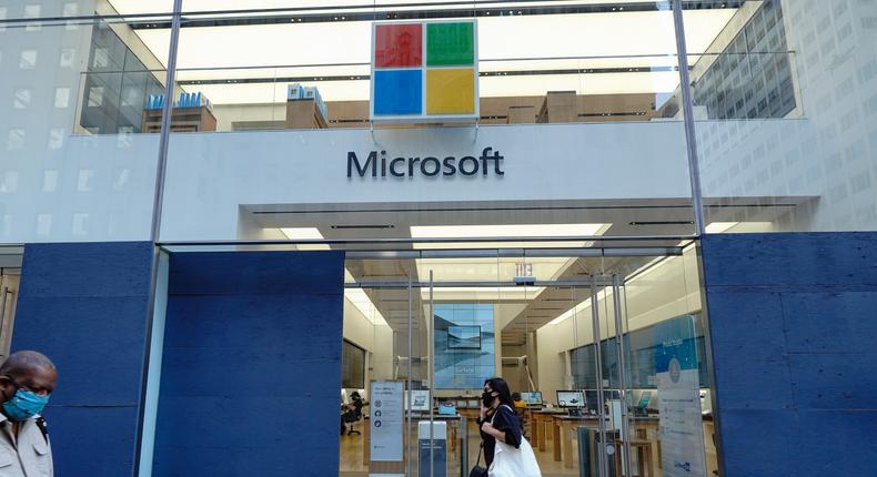 A woman walks past a Microsoft Store on 5th avenue.