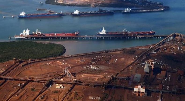 Ships waiting to be loaded are seen near piles of iron ore and bucket-wheel reclaimers at the Fortescue loading dock located at Port Hedland in the Pilbara region of Western Australia, in a file photo. REUTERS/David Gray
