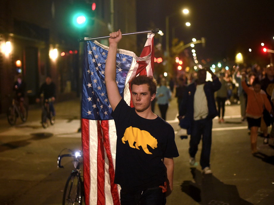 A person waves a flag during an anti-Trump demonstration in Oakland.