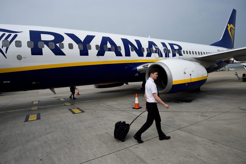 A cabin crew member serves passengers onboard a Ryanair passenger aircraft travelling from Madrid In