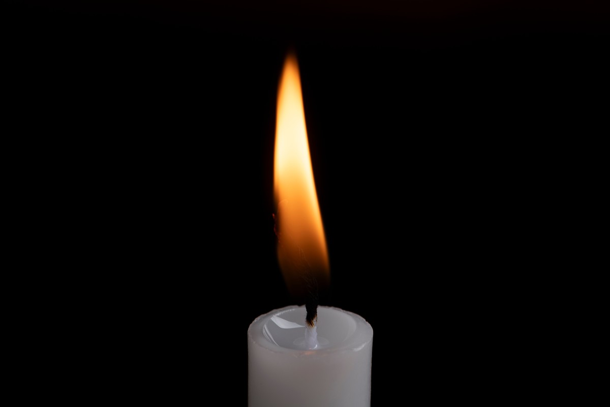 A,Candle,Flame,Glowing,Against,A,Dark,Background