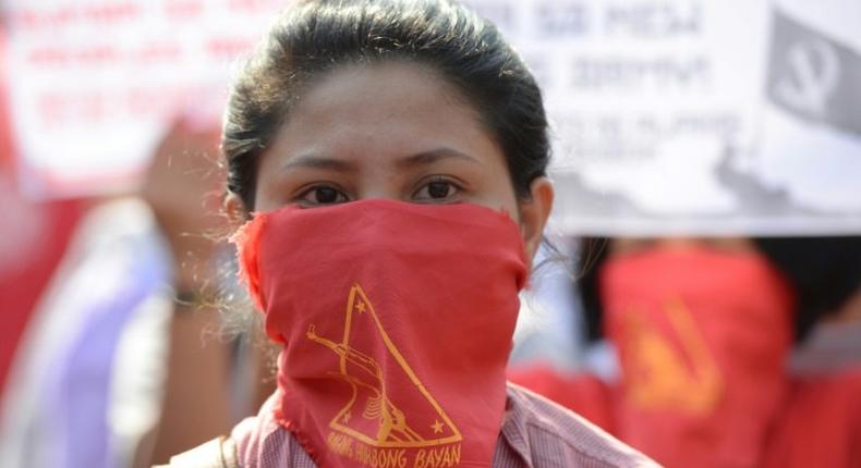 Members and supporters of the communist party of the Philippines' armed group, the New People's Army (NPA) march toward the peace arch for a protest near Malacanang Palace in Manila on March 31, 2017