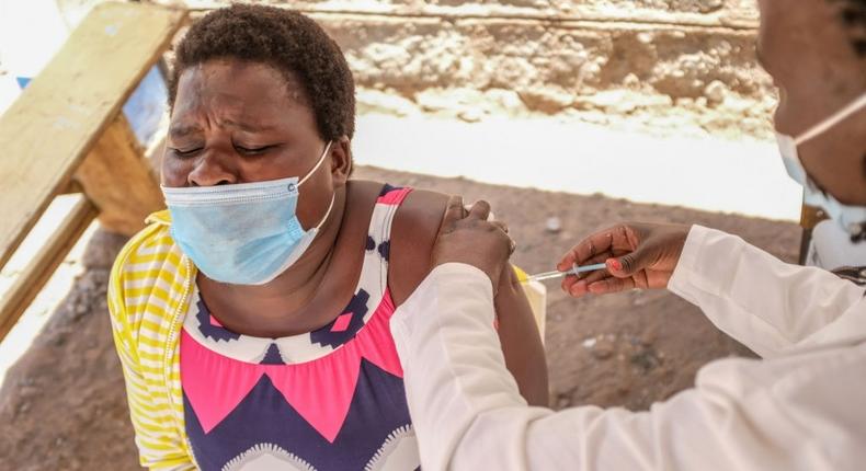 NAIROBI, KENYA - 2021/10/14: A resident in Kibera Slum is inoculated with a dose of Oxford-AstraZeneca covid-19 vaccine by a health worker. Despite the lack of resources and trying to make all ends meet, the residents in the Kibera slums took advantage of the opportunity given by the government to get inoculated with a free covid-19 vaccine. (Photo by Donwilson Odhiambo/SOPA Images/LightRocket via Getty Images)