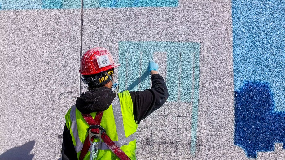 To get Odell's designs off the computer and into the real world, painters use an electric pen to trace the images onto paper, burning lines of small holes that ultimately transfer the correct outline to the wall when chalk dust is rubbed over them.