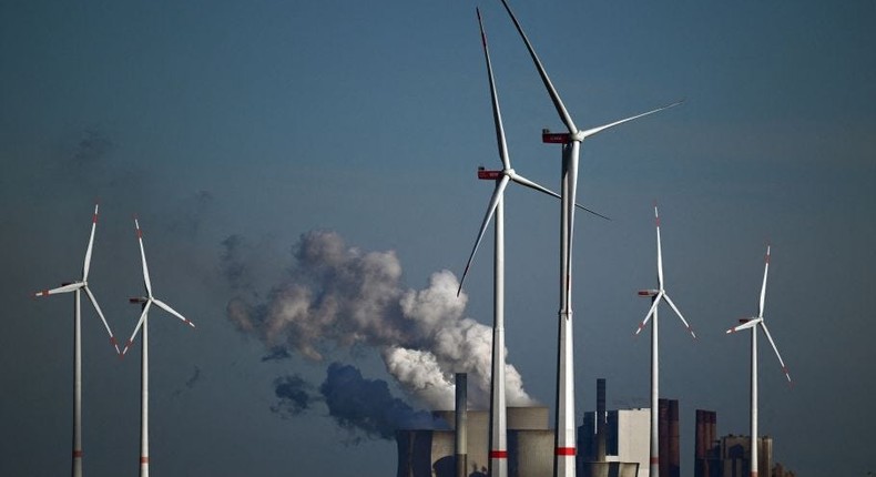 Wind turbines spin in front of a coal-fired power plant.Ina Fassbender/AFP