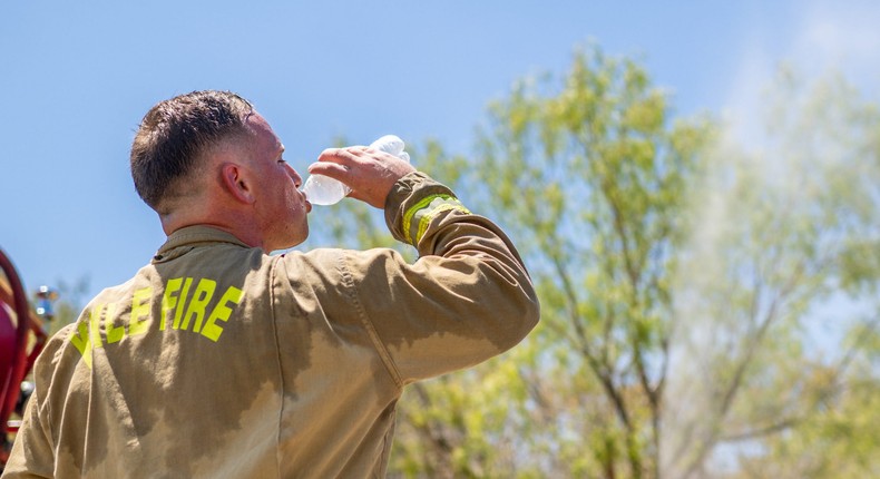 A fire fighter in Texas drinks water in the heat.BRANDON BELL/Getty Images