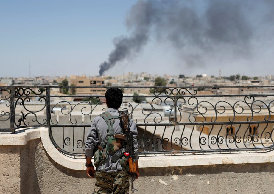 A Kurdish fighter from the People's Protection Units (YPG) looks on after an coalition airstrike in Raqqa, June 16, 2017.