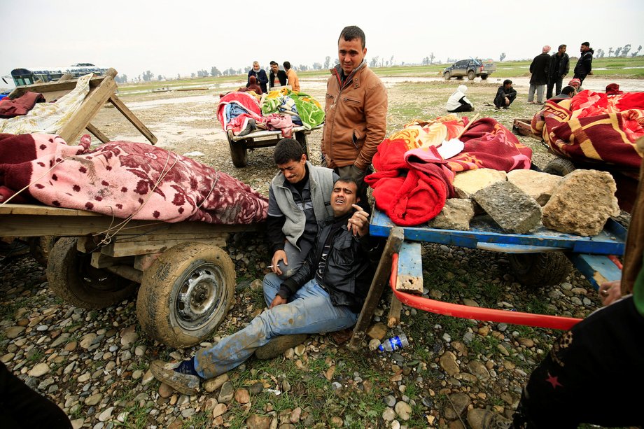 Relatives near the bodies of civilians killed in an air strike during battle between Iraqi forces and ISIS militants, in Mosul, March 17, 2017.