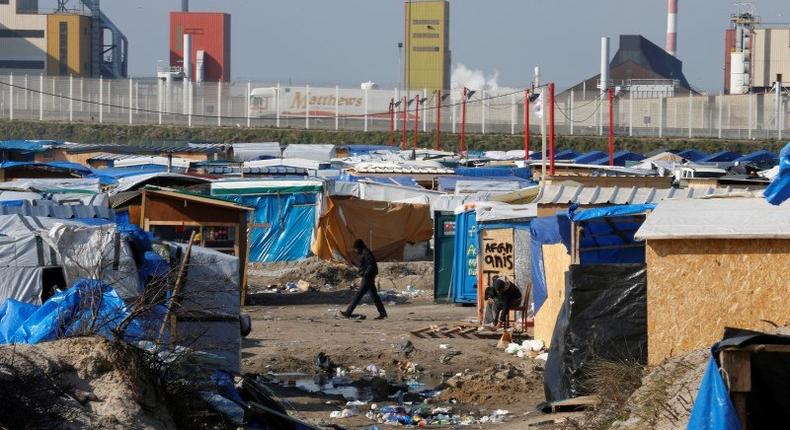 A migrant walks past makeshift shelters in the northern area on the final day of the dismantlement of the southern part of the camp called the 'Jungle in Calais, France, March 16, 2016. 