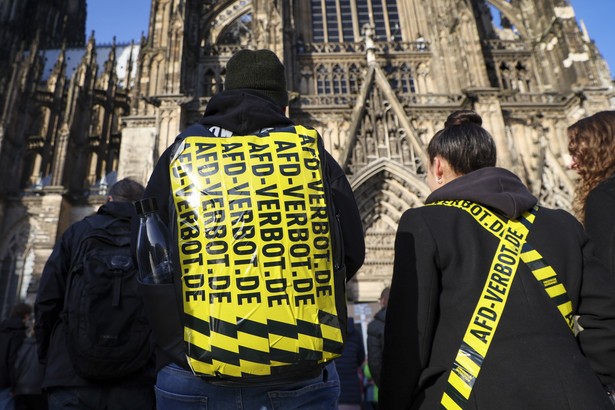 Protestujący z taśmą anty-AFD na plecach przed katedrą w Kolonii podczas demonstracji przeciwko skrajnie prawicowej partii Alternatywa dla Niemiec