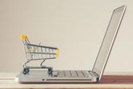 Small Shopping Cart On Laptop With Copyspace : Online Shopping Concept. E-commerce.