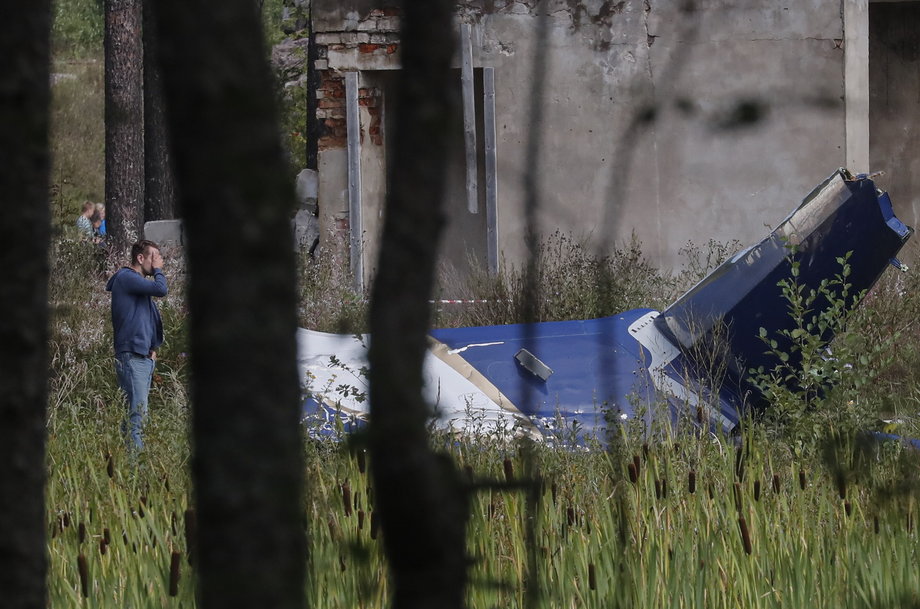 Mężczyzna stoi obok szczątków samolotu, którym leciał Jewgienij Prigożyn, 24 sierpnia 2023 r. 