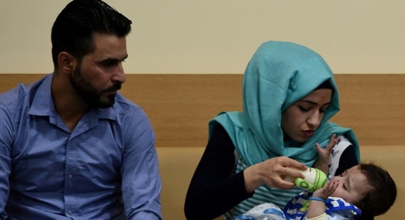 Parents Gufran Ali (C) and Sarwed Ahmed Nadar with their seven-month-old son Karam after his surgery in India to successfully remove his extra arms and legs