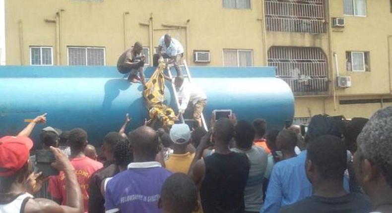 The corpse of the fuel thief being removed from the petrol tanker